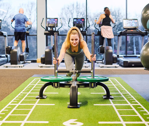 Image of woman pushing a sled in the gym at David Lloyd